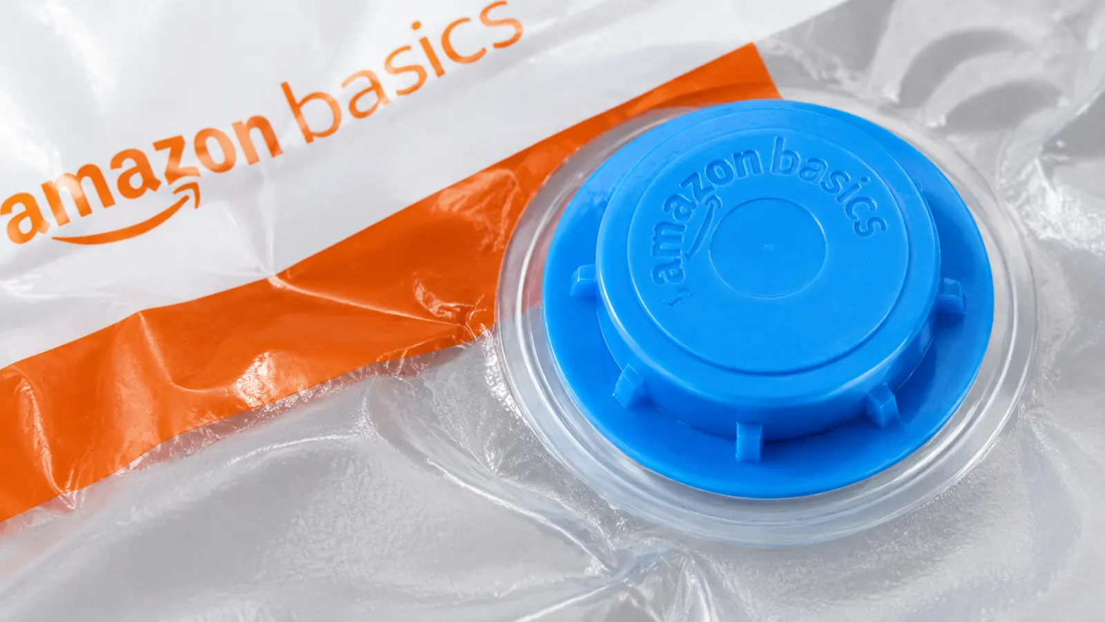 Close-up of a vacuum bag valve clogged with gray fabric lint and debris next to a cotton swab for scale